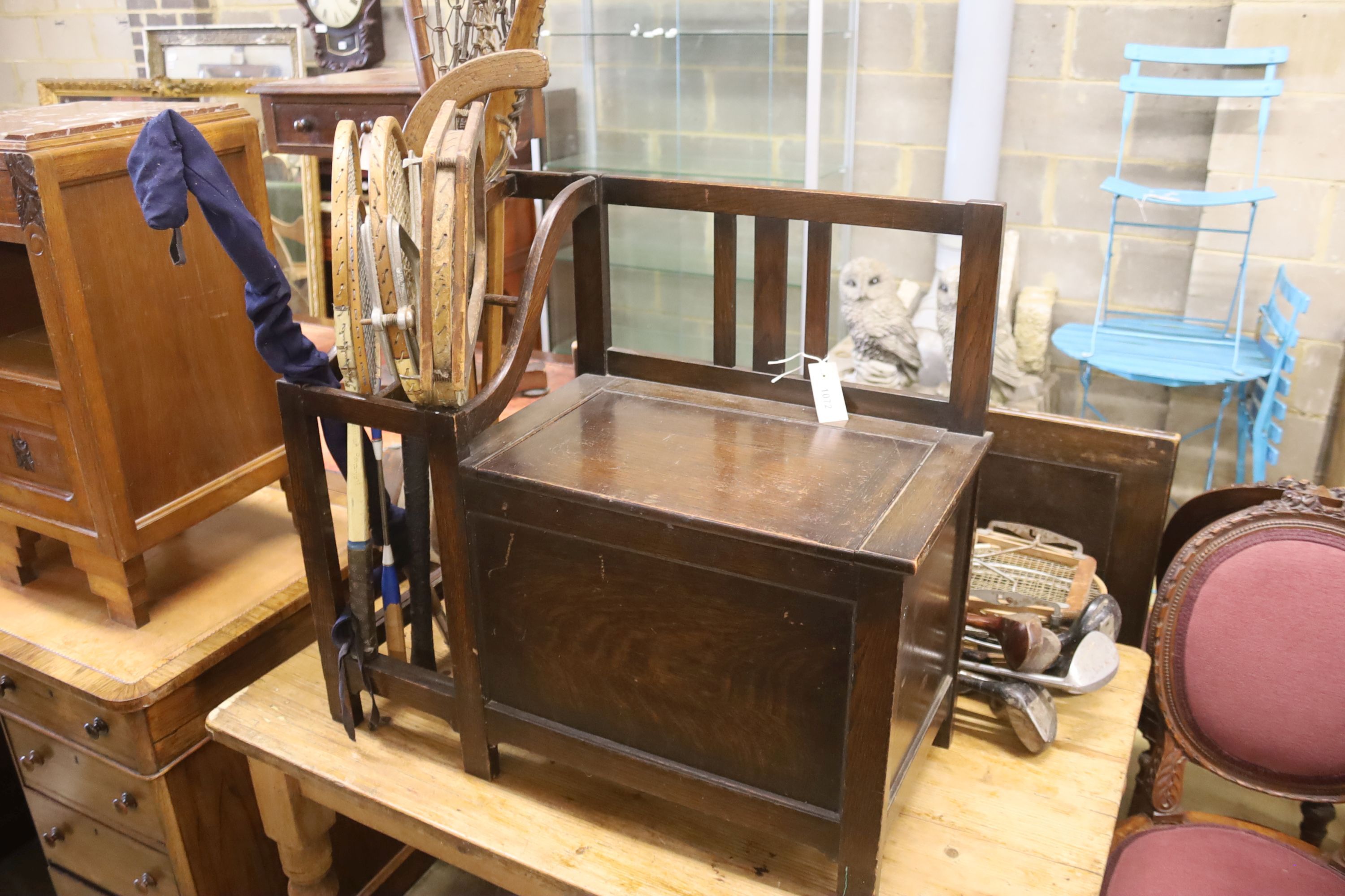 A 1920's oak hall seat together with a collection of vintage lacrosse sticks, golf clubs, etc.